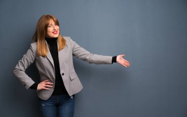 Geri işaret ve bir ürün sunma redhead iş kadını