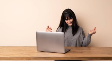 Para jest yapma onu laptop ile çalışan genç kadın