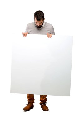 Boş bir afiş tutarak sakallı yakışıklı adam
