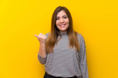 Ürün sunmak için genç kız tarafına işaret sarı duvarın üzerinden