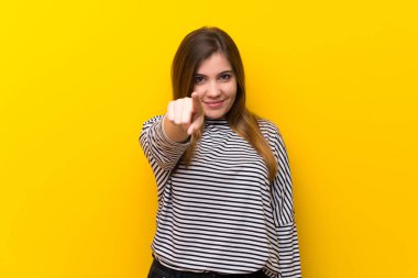 Genç kız sarı duvarın üzerinden parmak seni kendinden emin bir ifadesiyle işaret