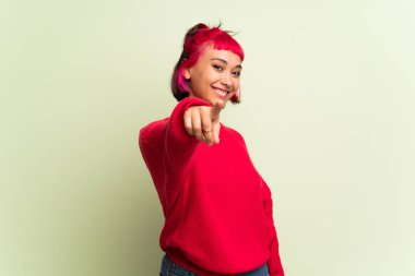 Kırmızı kazaklı genç kadın seni kendinden emin bir ifade ile parmak işaret