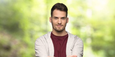 Kazak boşaltmak hayali avuç içinde tutan adamla bir parkta bir reklam eklemek için