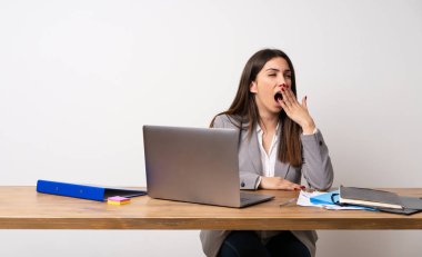 İş kadını esneme ve el ile geniş açık ağız kapsayan bir ofiste