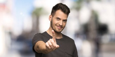 Adam ile gösterilen ve açık havada parmak kaldırma siyah gömlek