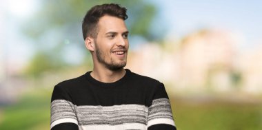 Yakışıklı adam mutlu ve açık havada gülümseyen