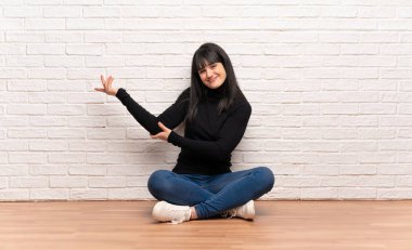 Eller yanına gelmek için davet için uzanan katta oturan kadın