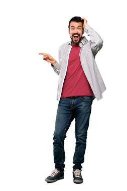 Yan tarafa izole beyaz arka plan için sakal şaşırmış ve işaret parmağınızla yakışıklı adamın tam uzunlukta atış