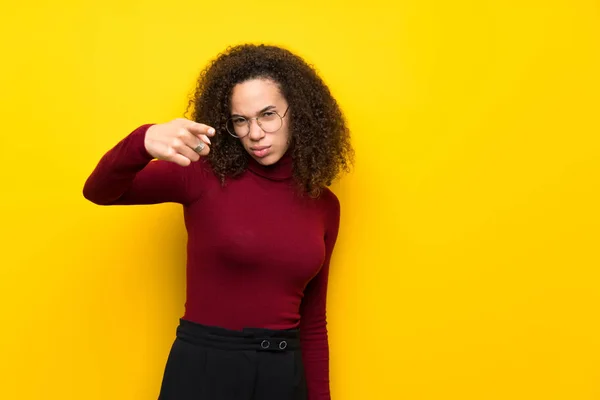 Dominican woman with turtleneck sweater frustrated and pointing to the front