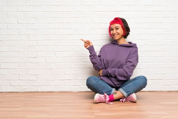 Mujer Joven Con Pelo Rosa Sentada Suelo Señalando Con Dedo — Foto de Stock