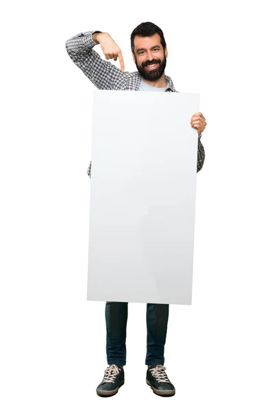 Homem bonito feliz com barba segurando um cartaz vazio — Fotografia de Stock