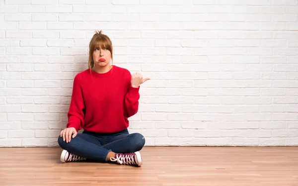 Rothaarige Frau Sitzt Unglücklich Auf Dem Boden Und Zeigt Zur — Stockfoto