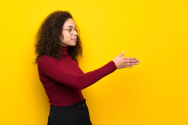 Dominican woman with turtleneck sweater handshaking after good deal