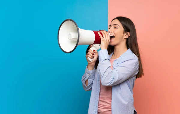 Mujer Joven Sobre Pared Rosa Azul Gritando Través Megáfono —  Fotos de Stock