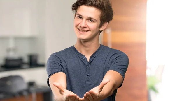 Teenager Man Holding Copyspace Imaginary Palm Insert Indoors — Stock Photo, Image