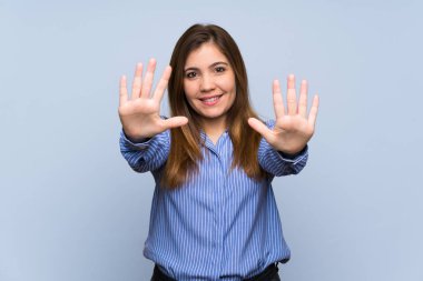 On parmak ile sayma izole mavi duvarın üzerinden genç kız