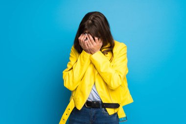 Yorgun ve hasta ifade mavi zemin üzerine sarı ceket Bayan