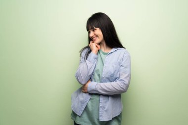 Yeşil duvar tarafına el ile çeneme arıyorum genç kadın