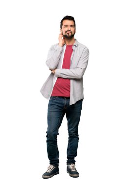 İzole beyaz arka plan üzerinde şüpheleri sakallı yakışıklı adam tam uzunlukta atış