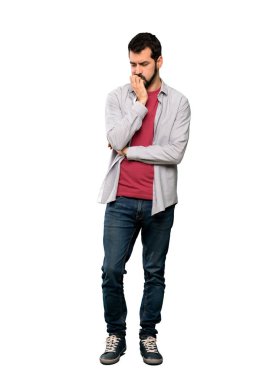 İzole beyaz arka plan üzerinde şüpheleri sakallı yakışıklı adam tam uzunlukta atış