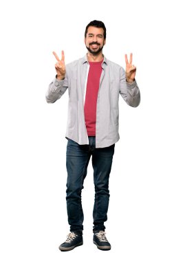 Zafer işareti her iki el ile izole beyaz arka plan üzerinde gösterilen sakallı yakışıklı adam tam uzunlukta atış