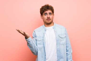 Sarışın adam pembe duvar önemsiz jest yapma