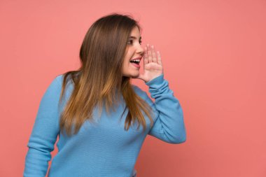 Geniş açık ağız ile bağırarak mavi kazaklı genç kız