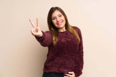 Gülümseyen ve zafer işaret gösteren genç kız
