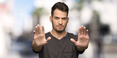 Adam siyah gömlek yapma dur hareketi ile ve açık havada, hayal kırıklığına