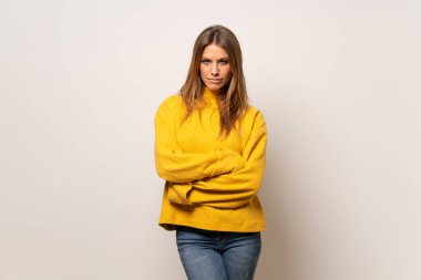 Yalıtılmış duvar portre üzerinde sarı kazaklı kadın