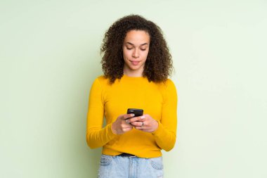 Mobil ileti gönderme izole yeşil arka plan Dominik kadın