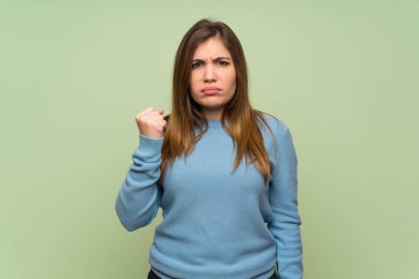 Genç kız yüzünden kızgın hareketi ile yeşil duvar