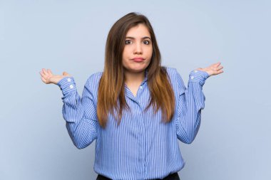 Genç kız izole mavi duvar eller yükselterek süre şüpheleri üzerinde