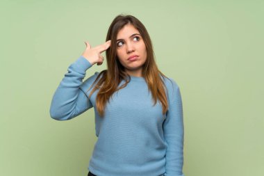 Genç kız intihar jest yapma sorunları olan yeşil duvar üzerinde