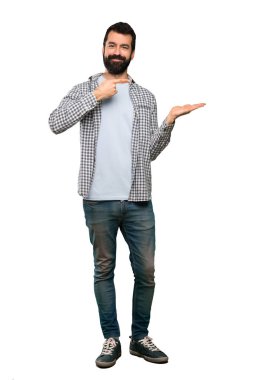 Boşaltmak hayali avuç içinde tutarak sakallı yakışıklı adam izole beyaz arka plan üzerinde bir reklam eklemek için