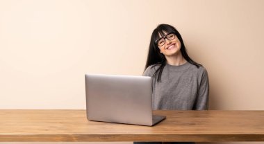 Genç kadın onu laptop ile gözlük ile çalışma ve mutlu