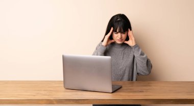 Baş ağrısı ile onu laptop ile çalışan genç kadın