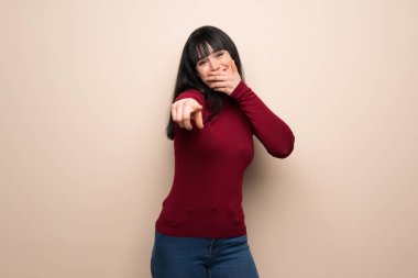 Birisi parmak ile işaret ve gülerek kırmızı balıkçı yaka ile genç kadın