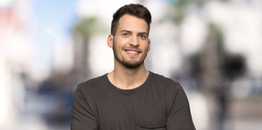 Açık havada, frontal pozisyonda siyah gömlek silah tutan adamla geçti