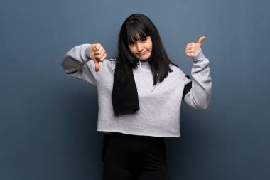 Genç kadın iyi-kötü işaret yapma evlat. Arasında kararsız Evet ya da değil