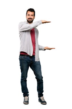 Tam uzunlukta atış boşaltmak tutan sakallı yakışıklı adam izole beyaz arka plan üzerinde bir reklam eklemek için