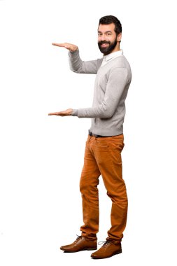 Yakışıklı adam boşaltmak tutan izole beyaz arka plan üzerinde bir reklam eklemek için