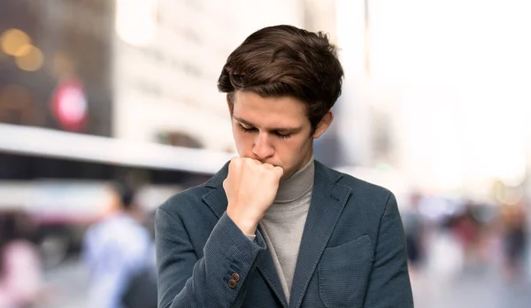 Teenager man with turtleneck having doubts at outdoors