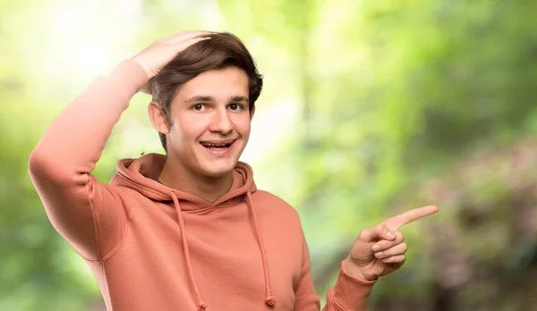 Hombre Adolescente Con Sudadera Sorprendida Señalando Con Dedo Hacia Lado —  Fotos de Stock