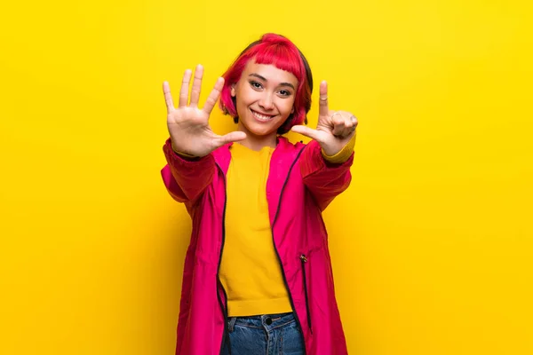 Jovem Com Cabelo Rosa Sobre Parede Amarela Contando Sete Com — Fotografia de Stock