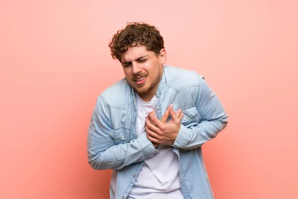 Homem Loiro Sobre Parede Rosa Que Tem Uma Dor Coração — Fotografia de Stock