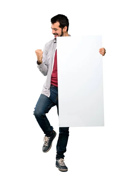 Homem bonito com barba segurando um cartaz vazio — Fotografia de Stock