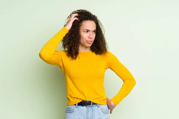 Dominicana Mulher Sobre Isolado Fundo Verde Com Dúvidas Coçar Cabeça — Fotografia de Stock