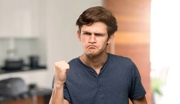 Teenager man with angry gesture at indoors