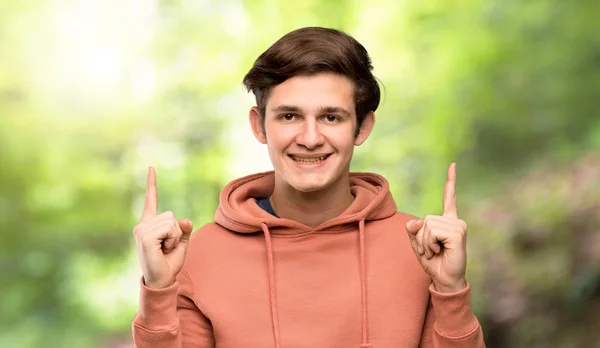 Teenager Man Sweatshirt Pointing Index Finger Great Idea Outdoors — Stock Photo, Image